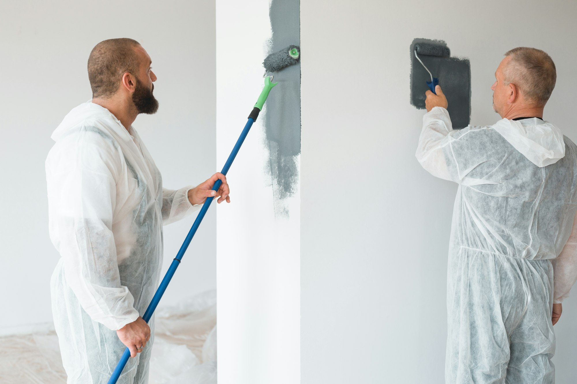 Professional renovation crew painting walls of new build apartment